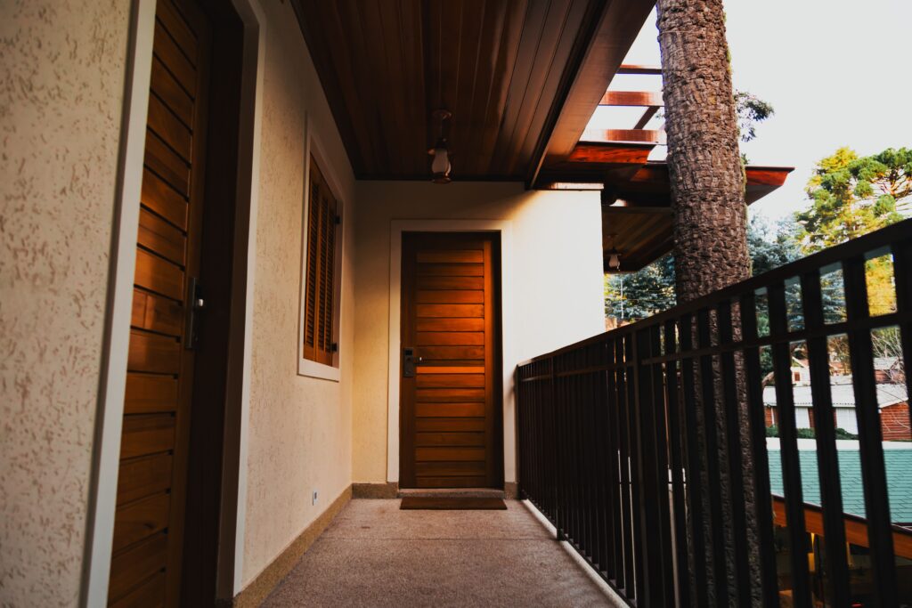 Contemporary apartment balcony featuring wooden doors and railing view.